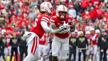 Nebraska running back Emmett Johnson takes a handoff from quarterback Dylan Raiola against Northwestern.