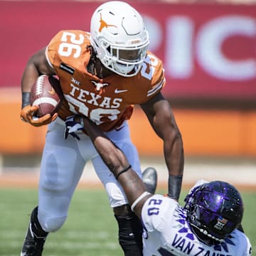 Oct 3, 2020; Austin, TX, USA; Texas Longhorns running back Keaontay Ingram (26) stiff arms TCU Horned Frogs safety La'Kendrick Van Zandt (20) in the 3th quarter in a NCAA college football game  at Darrell K Royal-Texas Memorial Stadium. Mandatory Credit: Ricardo B. Brazziell-Imagn Images