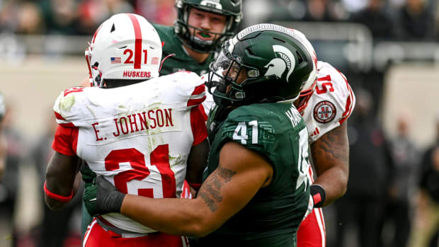 Michigan State's Derrick Harmon, right, tackles Nebraska's Emmett Johnson 