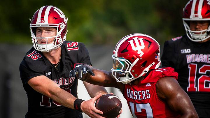 Indiana University's Tyler Cherry (15) hands off to Ty Son Lawton (17) during the first day of fall practice at the Mellencamp Pavilion at Indiana University on Wednesday, July 31, 2024.