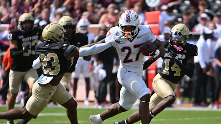 Sep 20, 2025; Blacksburg, Virginia, USA;  Virginia Tech Hokies running back Marcellous Hawkins (27) runs the ball as Wofford Terriers cornerback Cole Walker (23) defends during the first quarter at Lane Stadium. Mandatory Credit: Brian Bishop-Imagn Images
