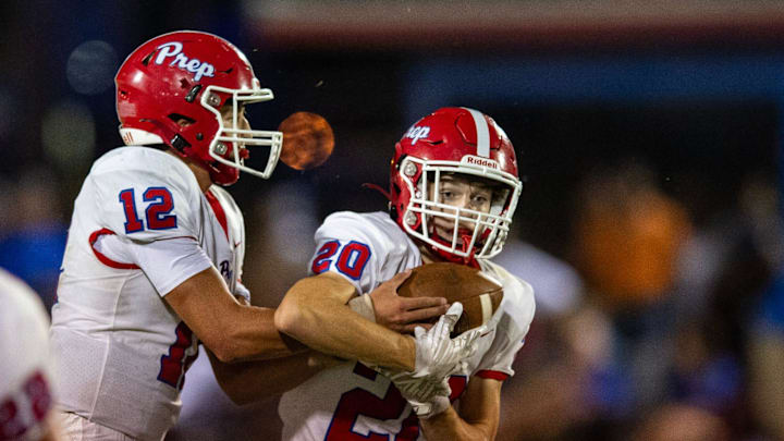 Jackson Prep Patriots' quarterback Parker Puckett (12) hands the ball off to running back Thomas Hewitt Oswalt (20) during the game against the Copiah Academy Colonels at Copiah in Hazlehurst, Miss., on Friday, Aug. 23, 2024.