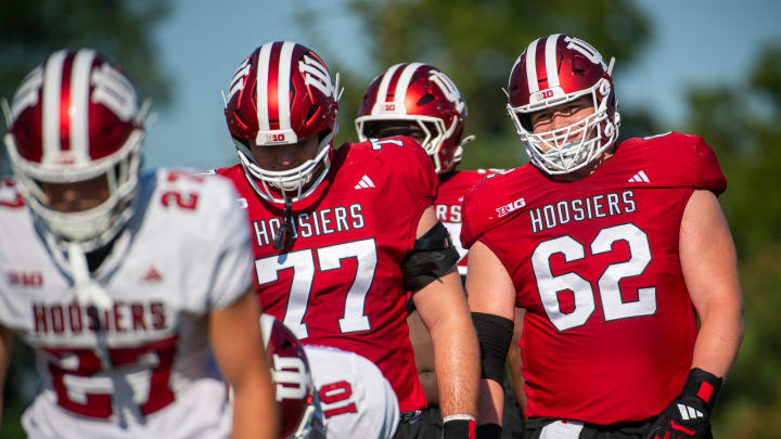 Indiana offensive linemen Drew Evans (62) and Tyler Stephens (77) warm up for fall practice.