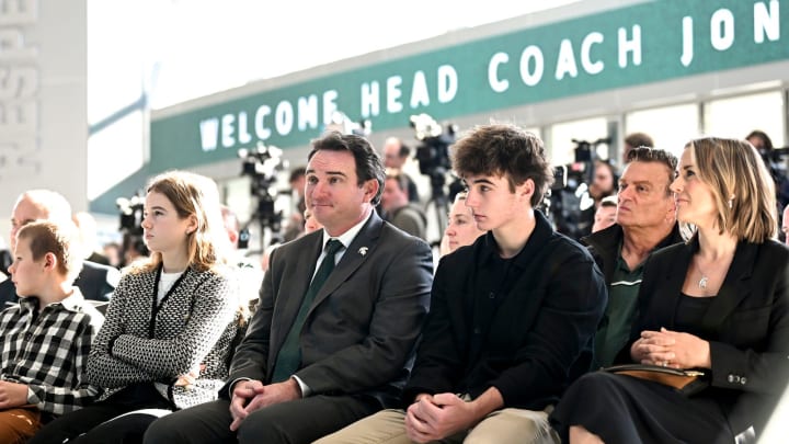 Michigan State football coach Jonathan Smith, center, sits with his family, from left, Charles,