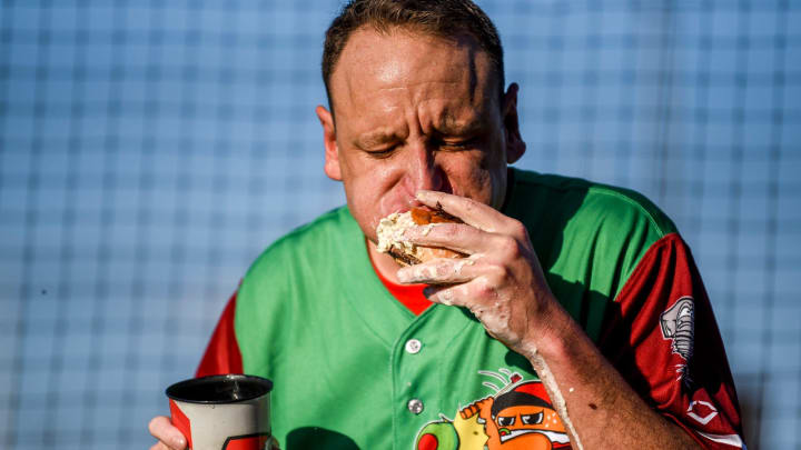 Nathan's Hot Dog Eating champion Joey Chestnut eats olive burgers before the Lugnuts game against the TinCaps in August 2023.