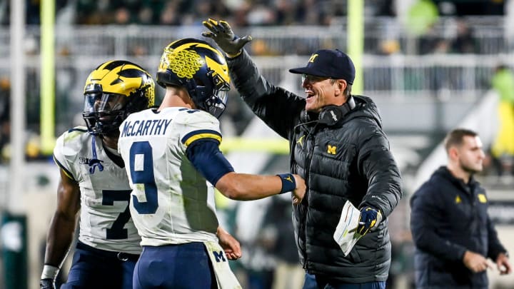 Michigan head coach Jim Harbaugh, right, celebrates with quarterback J.J. McCarthy after McCarthy's touchdown pass against Michigan State during the third quarter on Saturday, Oct. 21, 2023, at Spartan Stadium in East Lansing.