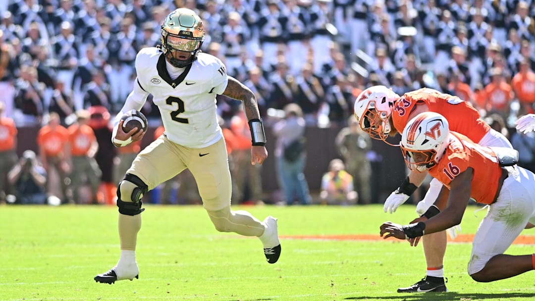 Oct 4, 2025; Blacksburg, Virginia, USA; Wake Forest Demon Deacons quarterback Robby Ashford (2) runs with the ball against Virginia Tech Hokies linebacker Noah Chambers (16) and defensive lineman Ben Bell (33) during the second quarter at Lane Stadium.