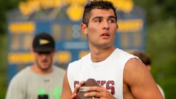 Dante Reno throws during a drill at the M2 QB Academy on Monday. Coach Mike McCarthy, far left, makes a video of the drill.