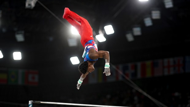 U.S. men's gymnast Fred Richard flys through the air upside down during the high bar competition at the Paris Olympics.