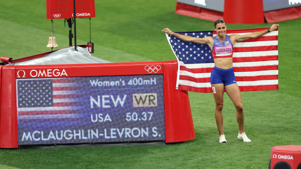 Sydney McLaughlin-Levrone poses with an American flag and time board, displaying her world record in the 400-meter hurdles.