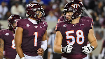 Sep 13, 2025; Blacksburg, Virginia, USA;  Virginia Tech Hokies quarterback Kyron Drones (1) and Virginia Tech Hokies offensive lineman Tommy Ricard (58) during the second quarter at Lane Stadium. Mandatory Credit: Brian Bishop-Imagn Images