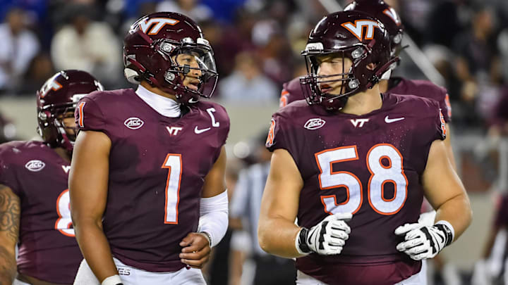 Sep 13, 2025; Blacksburg, Virginia, USA;  Virginia Tech Hokies quarterback Kyron Drones (1) and Virginia Tech Hokies offensive lineman Tommy Ricard (58) during the second quarter at Lane Stadium. Mandatory Credit: Brian Bishop-Imagn Images