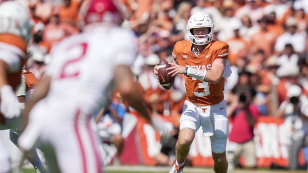 Texas Longhorns quarterback Quinn Ewers looks to pass against the Oklahoma Sooners in a college football game in the SEC.