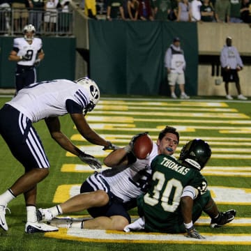 Nov. 1, 2008; Ft. Collins, CO, USA; BYU Cougars tight end Dennis Pitta (center) loses his helmet on a touchdown reception while being tackled in the end zone by Colorado State Rams defensive back Gerald Thomas (30) during second half at Hughes Stadium. BYU beat Colorado State 38-35. Mandatory Credit: Andrew Carpenean-USA TODAY Sports