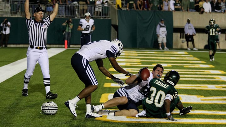 Nov. 1, 2008; Ft. Collins, CO, USA; BYU Cougars tight end Dennis Pitta (center) loses his helmet on a touchdown reception while being tackled in the end zone by Colorado State Rams defensive back Gerald Thomas (30) during second half at Hughes Stadium. BYU beat Colorado State 38-35. Mandatory Credit: Andrew Carpenean-USA TODAY Sports