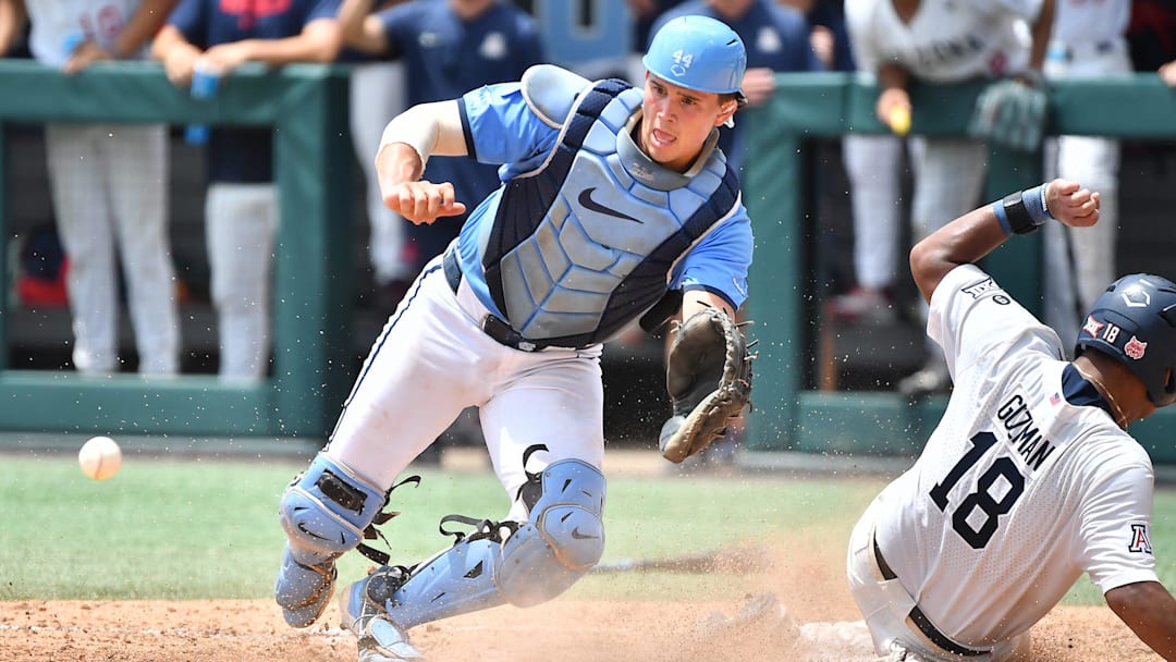 Arizona's Adonys Guzman (18) slides into home plate to score beating the throw to North Carolina catcher Luke Stevenson (44) . The North Carolina Tar Heels and the Arizona Wildcats met in game two of the NCAA Division 1 Super Regionals in Chapel Hill, N.C. on June 7, 2025.