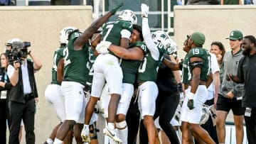 Michigan State's Antonio Gates Jr., center, is picked up by teammate Derrick Harmon and celebrated