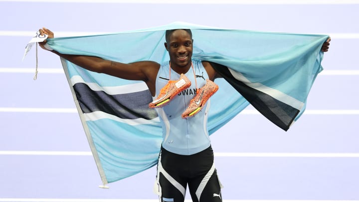 Botswana's Letsile Tebogo holds his country's flag up after winning the gold medal during the 200-meter final at the 2024 Paris Olympics.