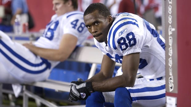 Former Colts wide receiver Marvin Harrisoon (white and blue jersey) looks on from the sideline.