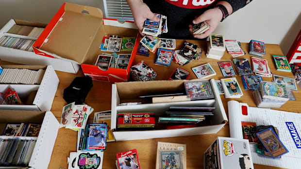 sports card collector looking at his card collection on a table spread out