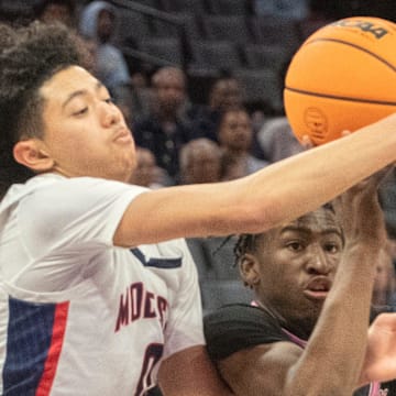 Lincoln's Donez Lindsey, right, fights for a loose ball with Modesto Christian's Myles Jones in the Sac-Joaquin Section boys basketball championship game at Golden One Center in Sacramento on Feb. 21. 2024. Modesto Christian won 68-63.