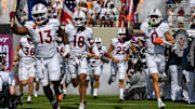 Sep 20, 2025; Blacksburg, Virginia, USA;  Virginia Tech Hokies defensive lineman Kemari Copeland (13), quarterback A.J. Brand (18) and wide receiver Ayden Greene (0) run onto the field before the game against The Wofford Terriers  at Lane Stadium. Mandatory Credit: Brian Bishop-Imagn Images