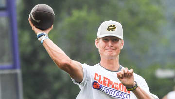 Brady Hart, left, of Cocoa Florida passes near Clemson offensive coordinator Garrett Riley during the 2024 Dabo Swinney Football Camp in Clemson in Clemson June 5, 2024.
