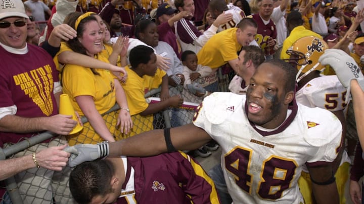 ASU's Terrell Suggs celebrates with the Sun Devils fans after ASU defeated the Wildcats 34-20 in Tucson on Nov. 29, 2002.