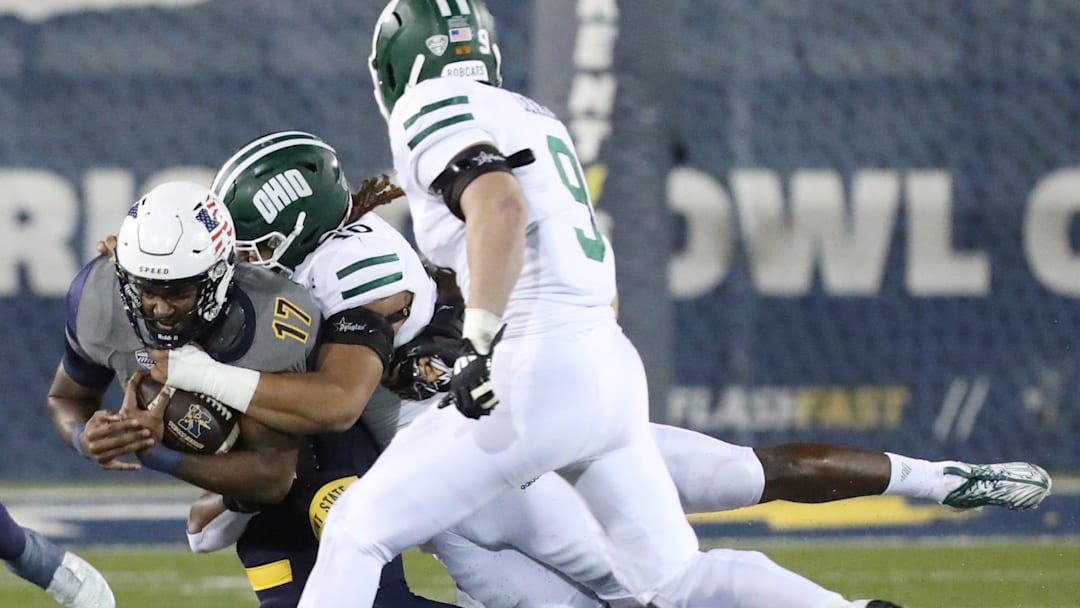 Kent State quarterback Ruel Tomlinson is tackled by Ohio Univeristy's Cam Rice as Blake Leake closes in on the play during the first half of their MAC game at Dix Stadium in Kent on Wednesday, Nov. 6, 2024.