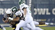 Kent State quarterback Ruel Tomlinson is tackled by Ohio Univeristy's Cam Rice as Blake Leake closes in on the play during the first half of their MAC game at Dix Stadium in Kent on Wednesday, Nov. 6, 2024.
