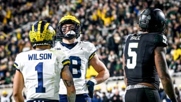 Michigan's Colston Loveland, center, poses like Paul Bunyan while celebrating his touchdown with teammate Roman Wilson as Michigan State's Jordan Hall, right, looks on during the second quarter on Saturday, Oct. 21, 2023, at Spartan Stadium in East Lansing.