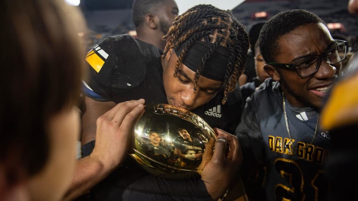 Oak Grove Warriors' running back Kylin Champagne (7) kisses the trophy after the Warriors won the MHSAA 7A football state title game at Vaught-Hemingway Stadium in Oxford, Miss., on Saturday, Dec. 2, 2023.