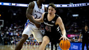 Cincinnati Bearcats guard Simas Lukosius (41) handles the ball as Kansas Jayhawks forward K.J. Adams Jr. (24) guards him in the second half of the Big 12 Conference tournament game between Cincinnati Bearcats and Kansas Jayhawks at T-Mobile Center in Kansas City, Mo., on Wednesday, March 13, 2024.
