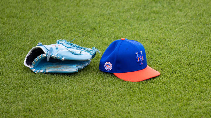 Feb 22, 2021; Port St. Lucie, Florida, USA; The hat and glove of New York Mets starting pitcher Marcus Stroman (0) sits on the outfield grass during the first day of full-squad spring training workouts at Clover Park.  Mandatory Credit: Mary Holt-USA TODAY Sports