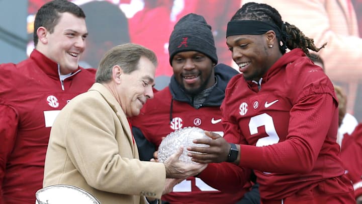 Alabama running back Derrick Henry (2) hands the Crystal trophy to coach Nick Saban, with offensive lineman Ryan Kelly (70) and linebacker Reggie Ragland (19), during a presentation to celebrate the victory in the CFP National Championship game at Bryant-Denny Stadium. 