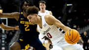 Cincinnati Bearcats guard Dan Skillings Jr. (0) drives on West Virginia Mountaineers guard Kobe Johnson (2) in the first half of the Big 12 Conference tournament between Cincinnati Bearcats and West Virginia Mountaineers at T-Mobile Center in Kansas City, Mo., on Tuesday, March 12, 2024.