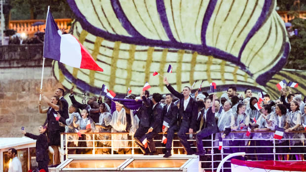 The French Olympic team waves flags during the Parade of Nations at the Olympic opening ceremony in Paris.