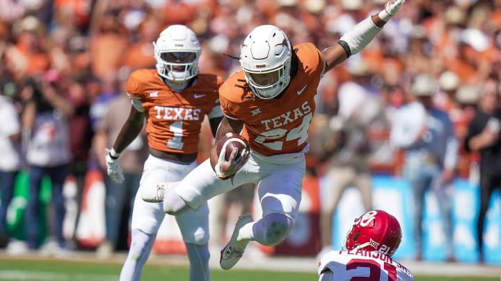 Texas Longhorns running back Jonathon Brooks (24) jumps over Oklahoma Sooners defensive back Reggie Pearson (21) for the first down in the third quarter during an NCAA college football game at the Cotton Bowl on Saturday, Oct. 7, 2023 in Dallas, Texas. This game makes up the119th rivalry match up.