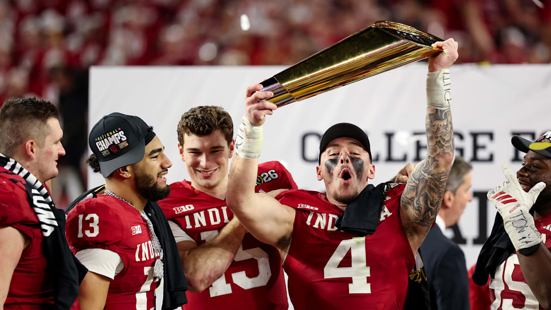 Indiana linebacker Aiden Fisher holds up the College Football Playoff national championship trophy.