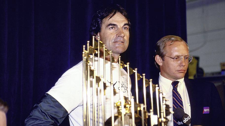 Oakland A's manager Tony La Russa victorious in locker room holding Commissioner's Trophy after winning 1989 World Series