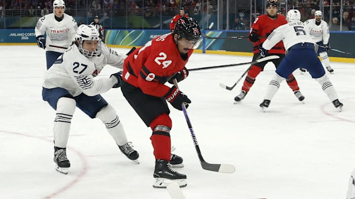 Feb 15, 2026; Milan, Italy; Antoine Keller of France in action with Seth Jarvis of Canada  in men's ice hockey group A play during the Milano Cortina 2026 Olympic Winter Games at Milano Santagiulia Ice Hockey Arena. Mandatory Credit: Geoff Burke-Imagn Images