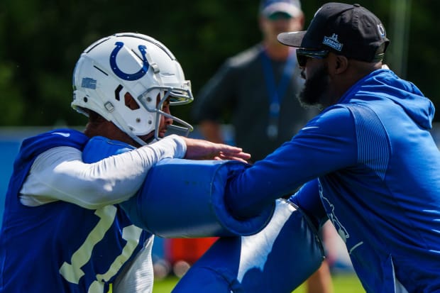 Indianapolis Colts wide receiver Michael Pittman Jr. (11) works through drills with coach Reggie Wayne in a blue jersey.