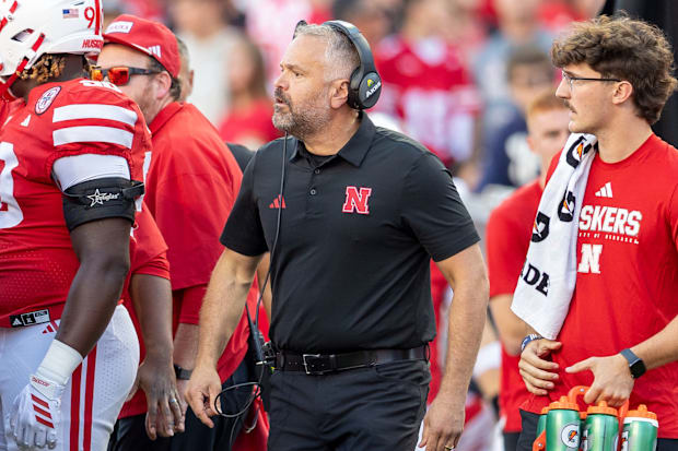 Nebraska football head coach Matt Rhule looks into a team huddle during the game against Akron.