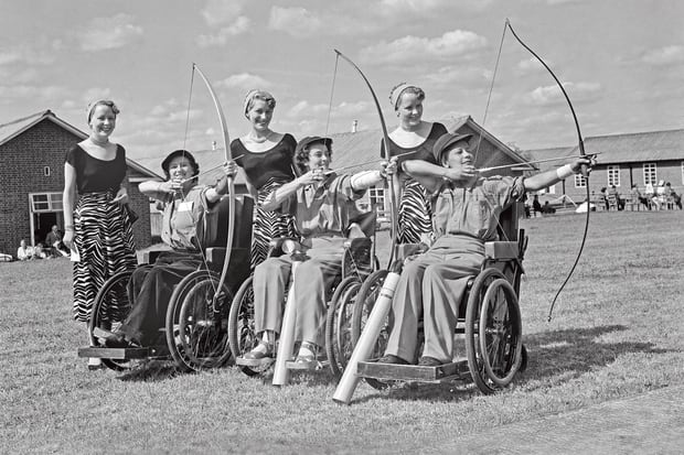 Competitors hold up bows and arrows for the Stoke Mandeville games in England. 