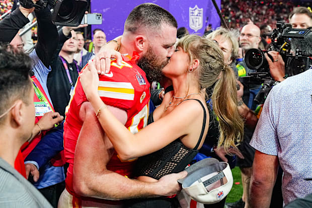 Chiefs Travis Kelce (87) kisses girlfriend and singer Taylor Swift following the Super Bowl 