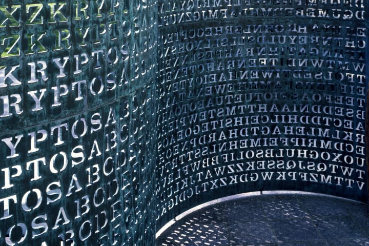 a close-up photograph of the CIA's 'kryptos' sculpture: wavy metal engraved with lines upon lines of encrypted letters
