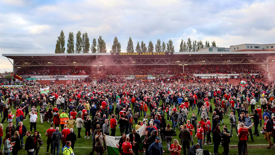 Wrexham fans rush the Racecourse Ground.
