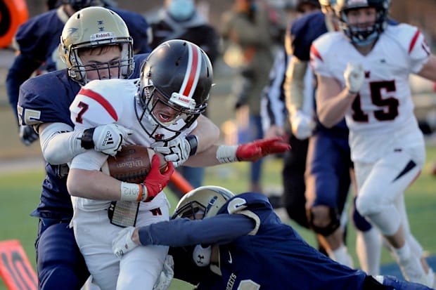 Wellesley running back James Dolan drags Needham defenders Tyler Harris and Hanson Miller to the goal line in 2021.