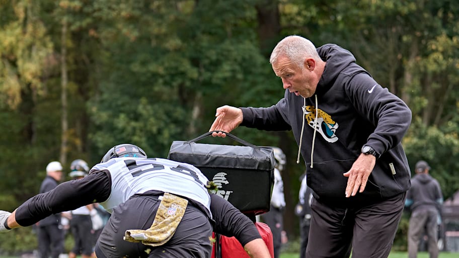 Richie Gray holds a tackling dummy for a Jaguars player at practice.