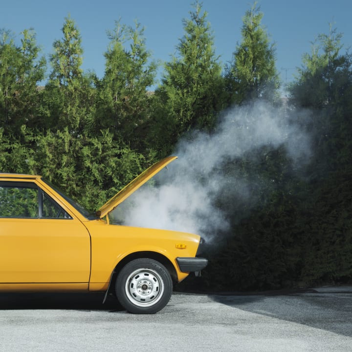 yellow car with smoke pouring from the hood